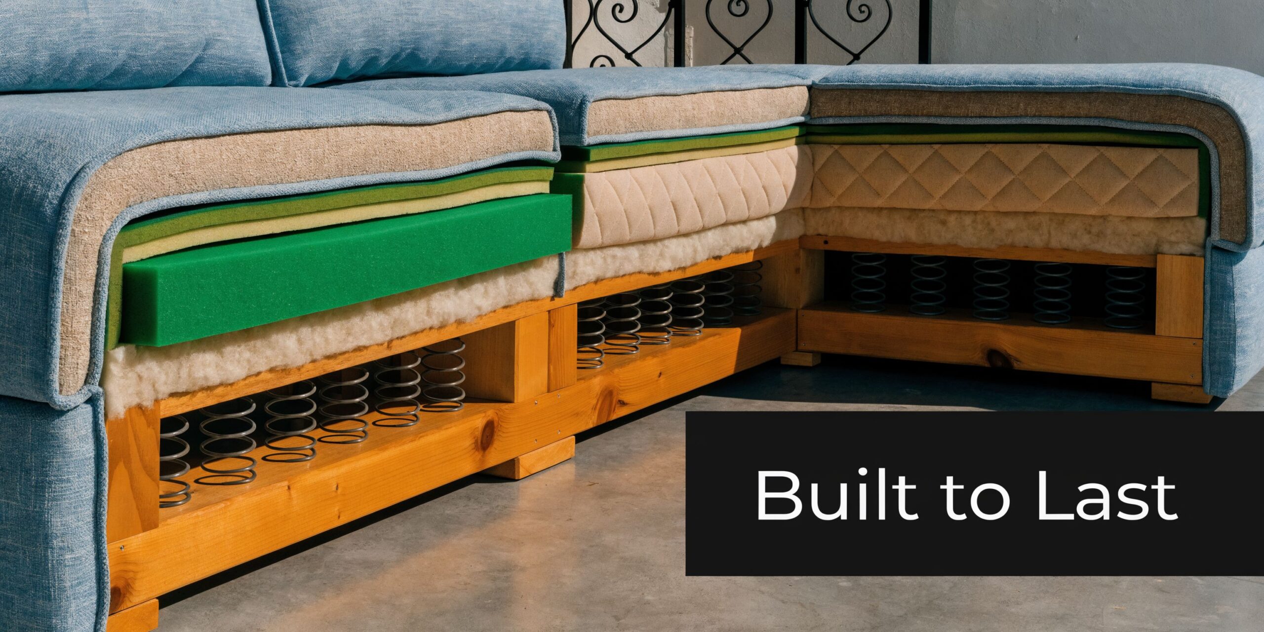 A cross-section view of a blue sectional sofa showing its internal wood frame, springs, and foam layers.