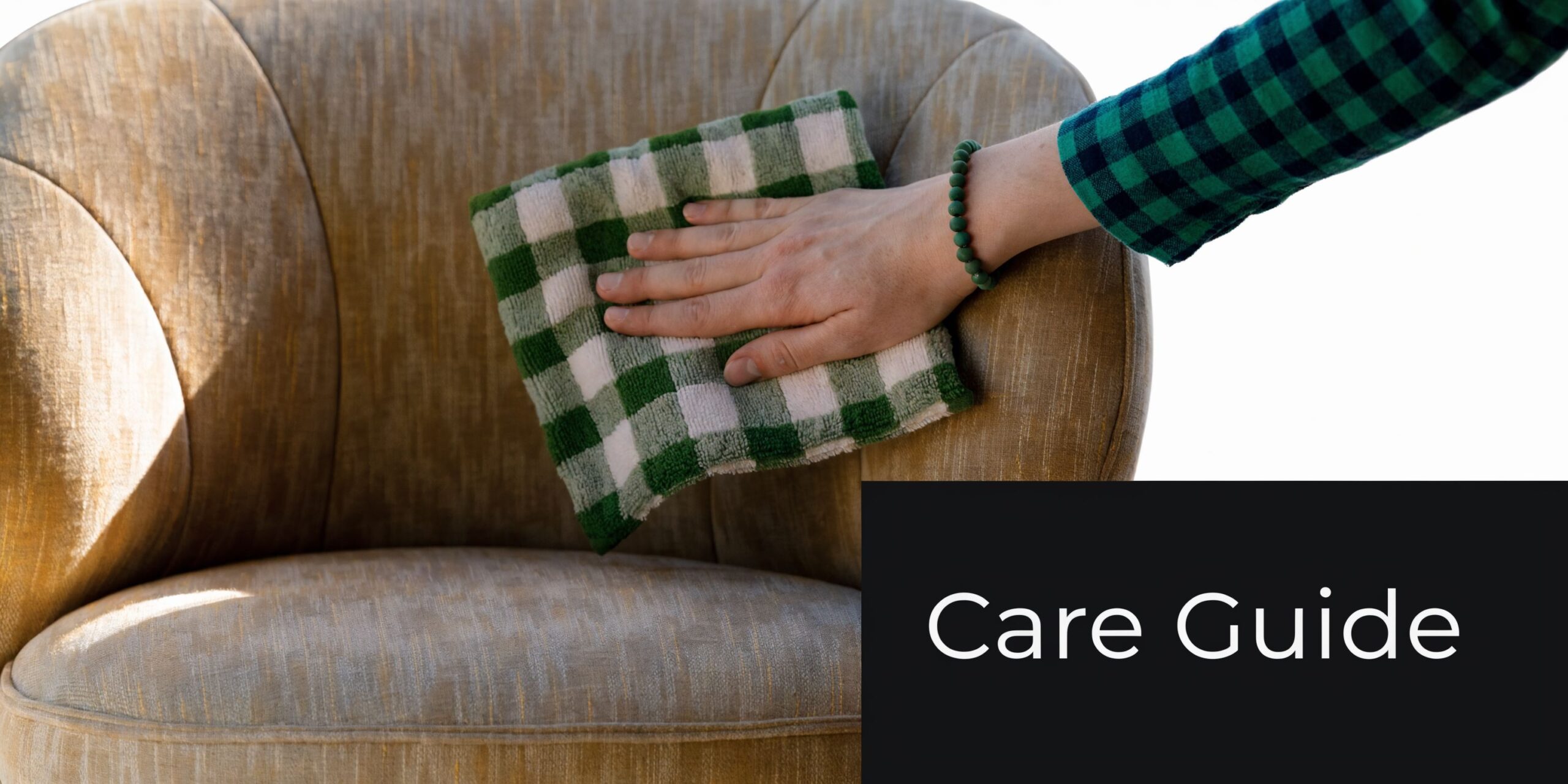 A hand using a green and white checkered cloth to wipe or clean an armless lounge chair.