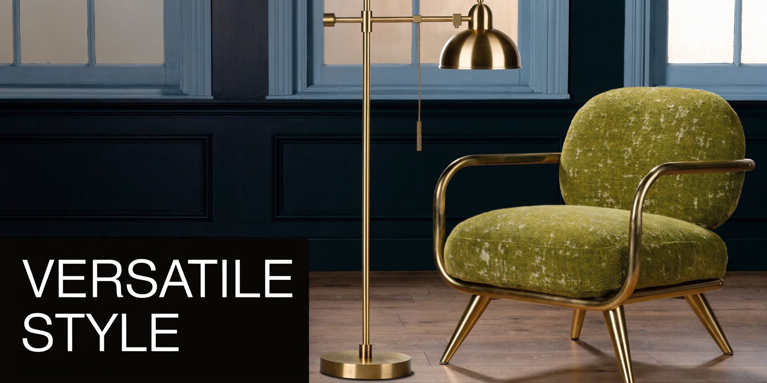 A luxurious green armchair with brass legs sits next to a sleek brass swing arm floor lamp.